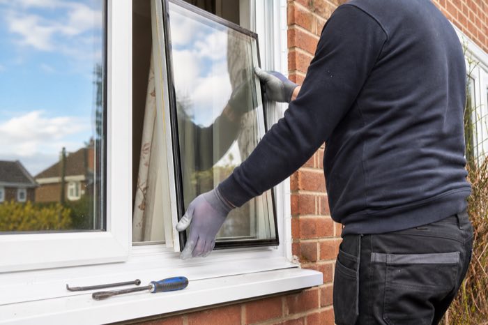 A technician replacing a failed sealed double glazed glass unit